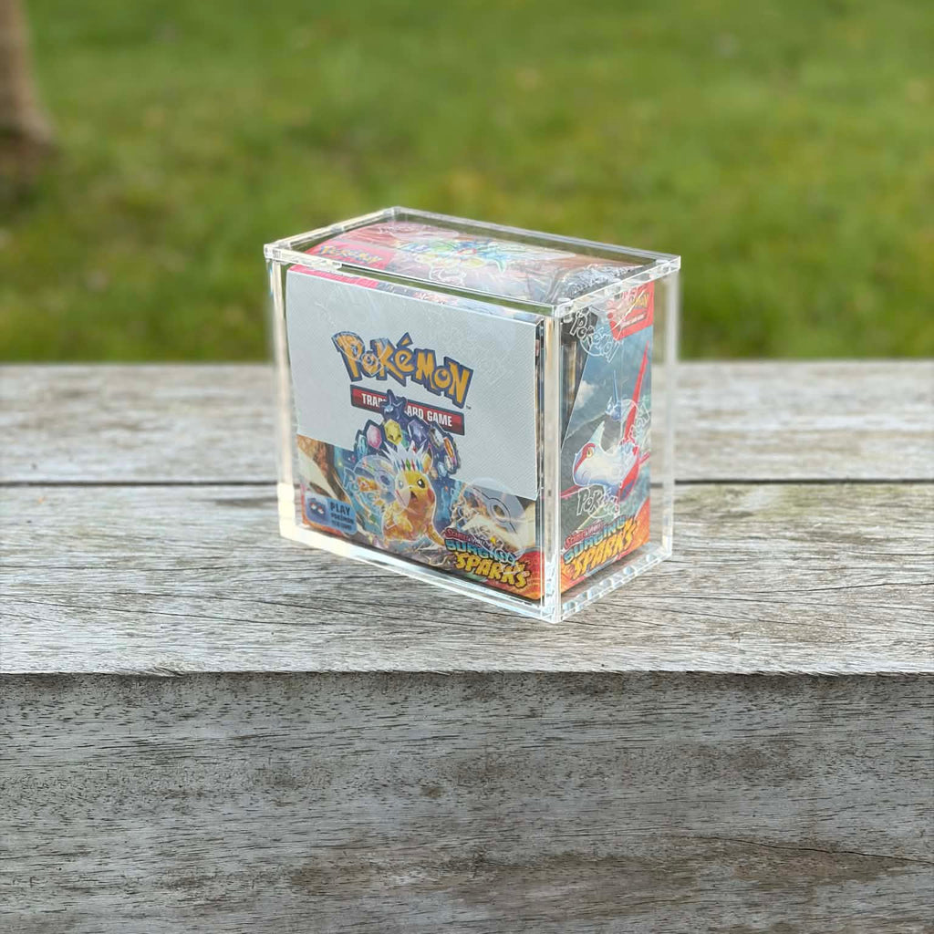 Pokémon trading card game box on a wooden surface with grass in the background